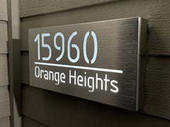 An illuminated Aluminum house sign that looks great during the day but truly shines at night with 46 LEDs and a dawn to dusk sensor -Brushed Aluminum